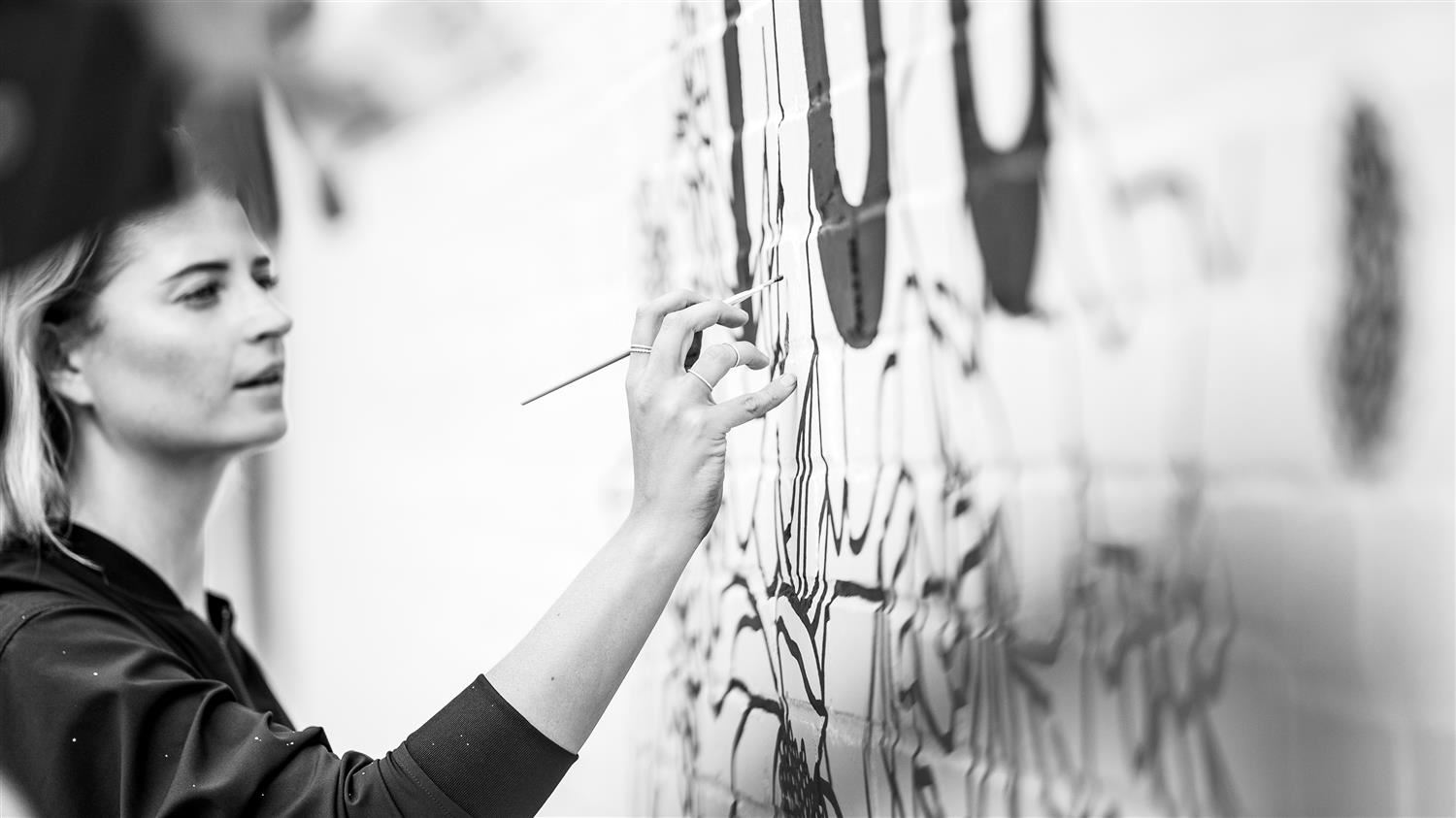  Artist Alli Koch paints a mural in downtown Richardson